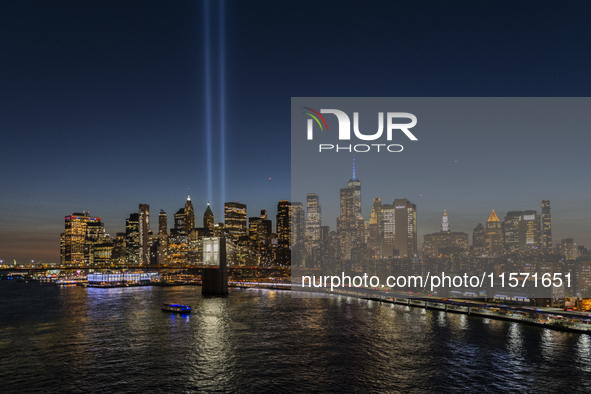 The annual Tribute in Light illuminates the skyline of lower Manhattan and One World Trade Center in New York City as it reflects in the top...