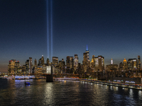 The annual Tribute in Light illuminates the skyline of lower Manhattan and One World Trade Center in New York City as it reflects in the top...