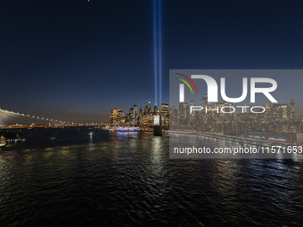 The annual Tribute in Light illuminates the skyline of lower Manhattan and One World Trade Center in New York City as it reflects in the top...