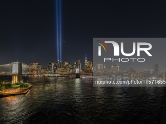 The annual Tribute in Light illuminates the skyline of lower Manhattan and One World Trade Center in New York City as it reflects in the top...