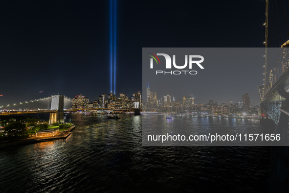 The annual Tribute in Light illuminates the skyline of lower Manhattan and One World Trade Center in New York City as it reflects in the top...