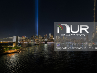 The annual Tribute in Light illuminates the skyline of lower Manhattan and One World Trade Center in New York City as it reflects in the top...