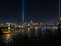 The annual Tribute in Light illuminates the skyline of lower Manhattan and One World Trade Center in New York City as it reflects in the top...