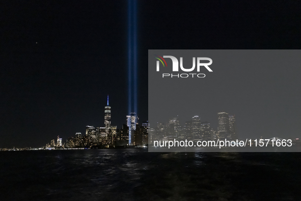 The annual Tribute in Light illuminates the skyline of lower Manhattan and One World Trade Center in New York City as it reflects in the top...