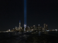 The annual Tribute in Light illuminates the skyline of lower Manhattan and One World Trade Center in New York City as it reflects in the top...