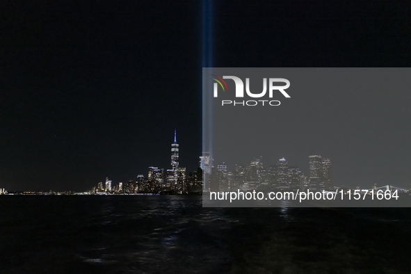 The annual Tribute in Light illuminates the skyline of lower Manhattan and One World Trade Center in New York City as it reflects in the top...