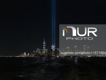 The annual Tribute in Light illuminates the skyline of lower Manhattan and One World Trade Center in New York City as it reflects in the top...