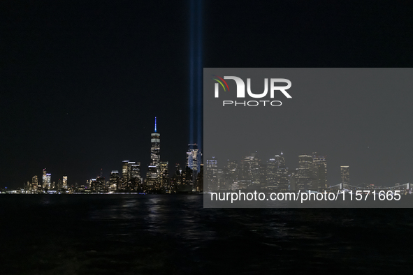 The annual Tribute in Light illuminates the skyline of lower Manhattan and One World Trade Center in New York City as it reflects in the top...