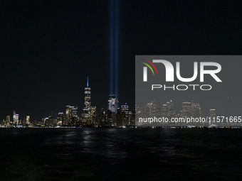 The annual Tribute in Light illuminates the skyline of lower Manhattan and One World Trade Center in New York City as it reflects in the top...