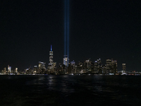 The annual Tribute in Light illuminates the skyline of lower Manhattan and One World Trade Center in New York City as it reflects in the top...