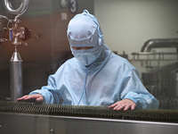 A worker checks a glass ampoule at a pharmaceutical company in Suqian, China, on September 13, 2024. (