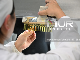 A worker tests diclofenac sodium injection at a pharmaceutical company in Suqian, China, on September 13, 2024. (