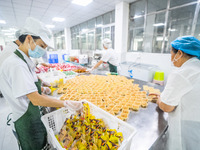 Workers make handmade mooncakes at a food production workshop in Bijie, China, on September 12, 2024. (