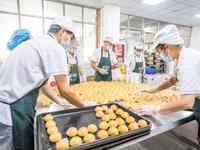 Workers make handmade mooncakes at a food production workshop in Bijie, China, on September 12, 2024. (