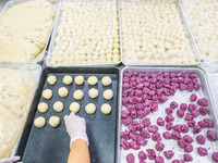 Workers make handmade mooncakes at a food production workshop in Bijie, China, on September 12, 2024. (