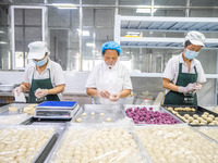 Workers make handmade mooncakes at a food production workshop in Bijie, China, on September 12, 2024. (