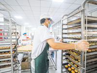 Workers make handmade mooncakes at a food production workshop in Bijie, China, on September 12, 2024. (