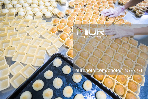 Workers make handmade mooncakes at a food production workshop in Bijie, China, on September 12, 2024. 