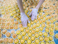 Workers make handmade mooncakes at a food production workshop in Bijie, China, on September 12, 2024. (