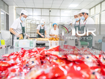 Workers make handmade mooncakes at a food production workshop in Bijie, China, on September 12, 2024. (