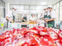 Workers make handmade mooncakes at a food production workshop in Bijie, China, on September 12, 2024. (