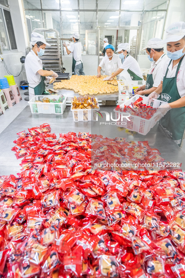 Workers make handmade mooncakes at a food production workshop in Bijie, China, on September 12, 2024. 