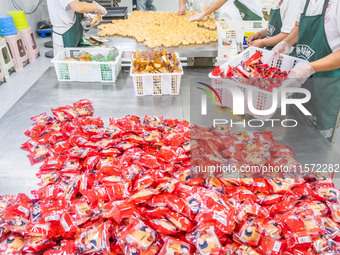 Workers make handmade mooncakes at a food production workshop in Bijie, China, on September 12, 2024. (