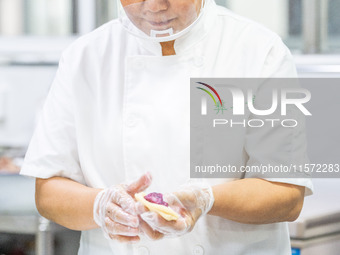 Workers make handmade mooncakes at a food production workshop in Bijie, China, on September 12, 2024. (