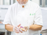 Workers make handmade mooncakes at a food production workshop in Bijie, China, on September 12, 2024. (