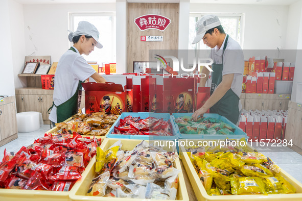 Workers make handmade mooncakes at a food production workshop in Bijie, China, on September 12, 2024. 