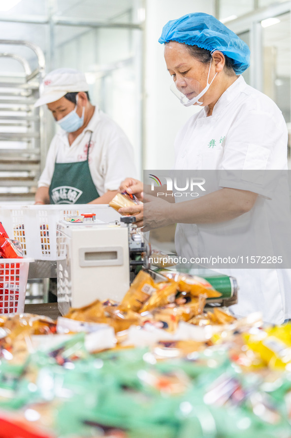 Workers make handmade mooncakes at a food production workshop in Bijie, China, on September 12, 2024. 