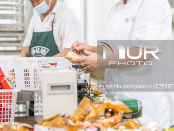 Workers make handmade mooncakes at a food production workshop in Bijie, China, on September 12, 2024. (