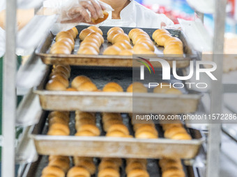 Workers make handmade mooncakes at a food production workshop in Bijie, China, on September 12, 2024. (