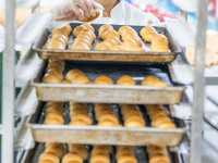 Workers make handmade mooncakes at a food production workshop in Bijie, China, on September 12, 2024. (