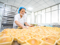 Workers make handmade mooncakes at a food production workshop in Bijie, China, on September 12, 2024. (