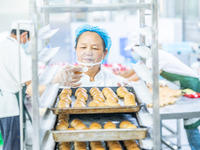 Workers make handmade mooncakes at a food production workshop in Bijie, China, on September 12, 2024. (