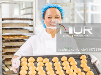 Workers make handmade mooncakes at a food production workshop in Bijie, China, on September 12, 2024. (