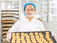 Workers make handmade mooncakes at a food production workshop in Bijie, China, on September 12, 2024. (