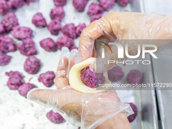 Workers make handmade mooncakes at a food production workshop in Bijie, China, on September 12, 2024. (