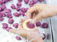 Workers make handmade mooncakes at a food production workshop in Bijie, China, on September 12, 2024. (