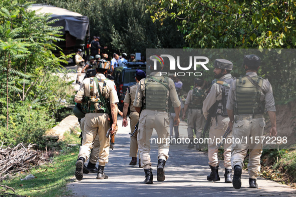 Indian Army, JK Police, and CRPF personnel rush towards the site where an encounter breaks out between security forces and militants at Chec...