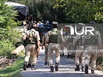 Indian Army, JK Police, and CRPF personnel rush towards the site where an encounter breaks out between security forces and militants at Chec...