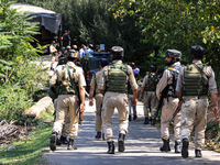 Indian Army, JK Police, and CRPF personnel rush towards the site where an encounter breaks out between security forces and militants at Chec...