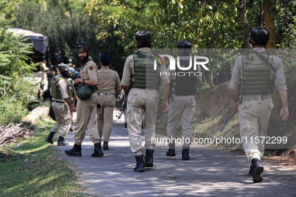 Indian Army, JK Police, and CRPF personnel rush towards the site where an encounter breaks out between security forces and militants at Chec...