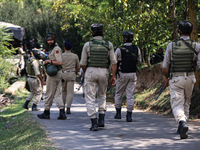 Indian Army, JK Police, and CRPF personnel rush towards the site where an encounter breaks out between security forces and militants at Chec...