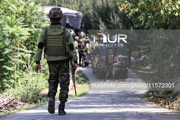 Indian Army, JK Police, and CRPF personnel rush towards the site where an encounter breaks out between security forces and militants at Chec...