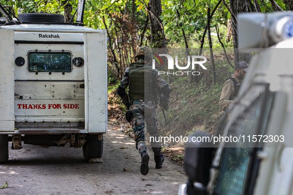 Indian Army, JK Police, and CRPF personnel rush towards the site where an encounter breaks out between security forces and militants at Chec...