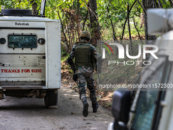 Indian Army, JK Police, and CRPF personnel rush towards the site where an encounter breaks out between security forces and militants at Chec...