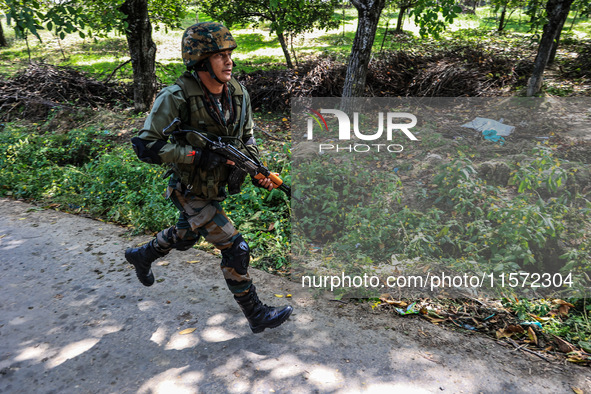 Indian Army, JK Police, and CRPF personnel rush towards the site where an encounter breaks out between security forces and militants at Chec...