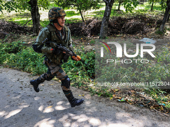 Indian Army, JK Police, and CRPF personnel rush towards the site where an encounter breaks out between security forces and militants at Chec...